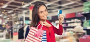 Women carrying small shopping bags and holding a credit card in her hands