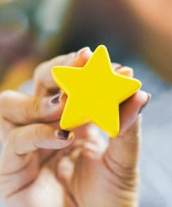 Hand holding yellow star with background blur