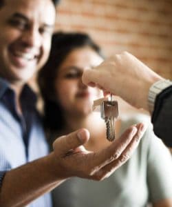Man handing over keys to a couple