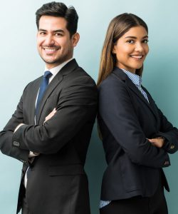 Two young business professionals smiling with fold hands facing the camera