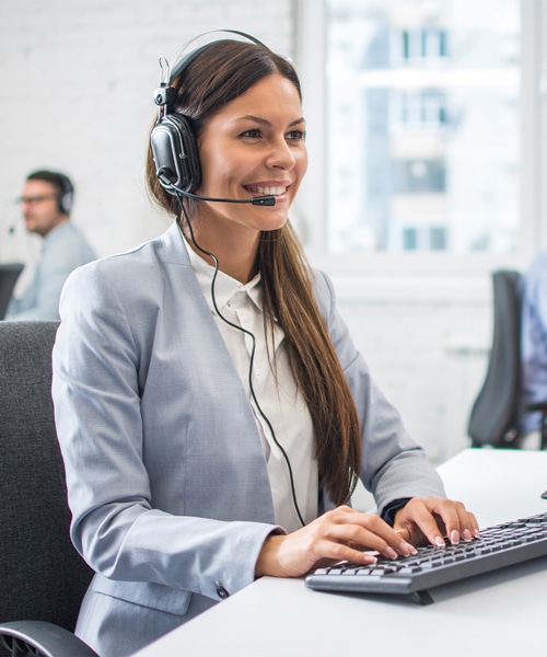 customer service representative wearing headset working on computer at call center office